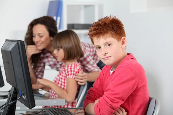 Enseignant et enfants apprenant à utiliser l'ordinateur — Photo