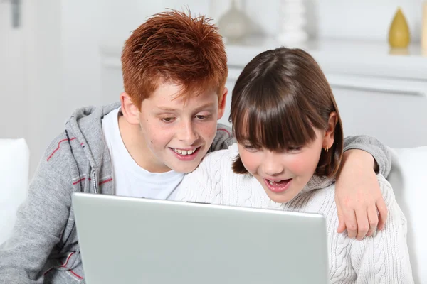 Giovane ragazzo e ragazza a casa con computer portatile — Foto Stock