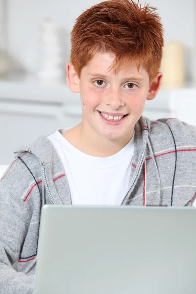 Close-up van jonge jongen thuis met laptopcomputer — Stockfoto