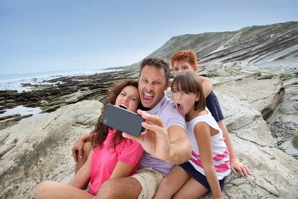 Padre tomando fotos de la familia frente al mar — Foto de Stock