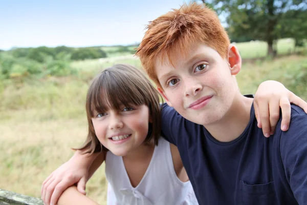 Brother and sister standing in field — Stock Photo, Image