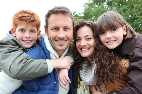 Parents doing piggyback to their children in countryside — Stock Photo, Image