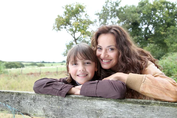 Mãe e filha se apoiando em uma cerca — Fotografia de Stock