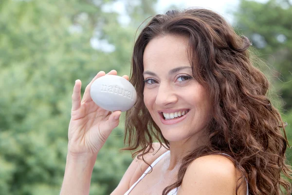 Closeup of beautiful woman holding stone — Stockfoto