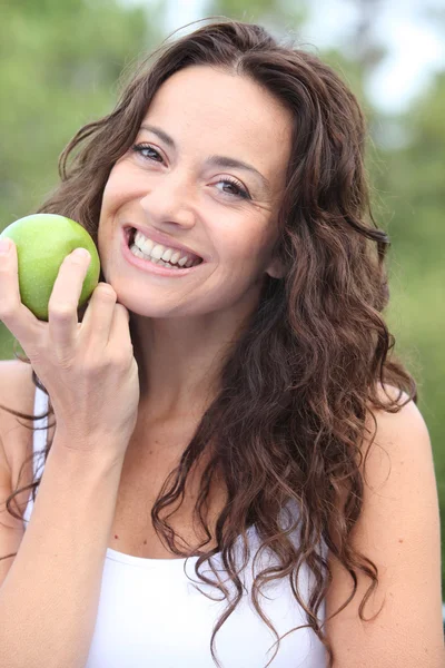 Closeup of woman eating a green apple — Stok fotoğraf