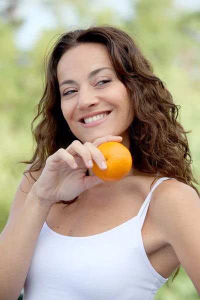 Close-up van vrouw eten een oranje — Stockfoto