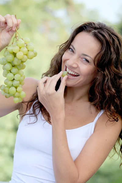 Closeup of woman eating grapes — Stock Photo, Image