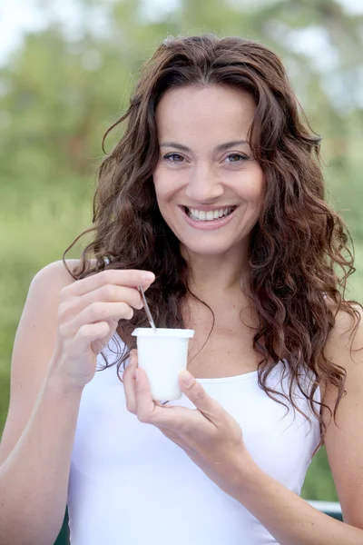 Closeup of beautiful woman eating yogurt — Stock Photo, Image