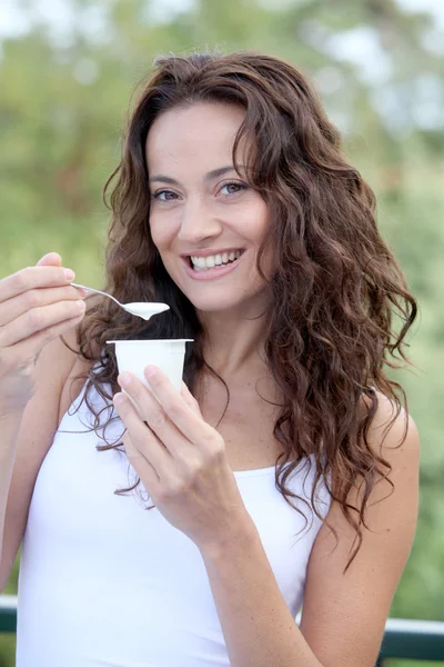 Closeup of beautiful woman eating yogurt — Stock Photo, Image