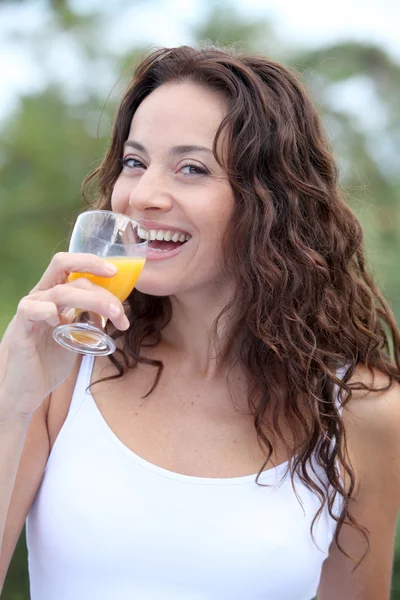 Fechar-se de mulher bonita bebendo suco de laranja — Fotografia de Stock