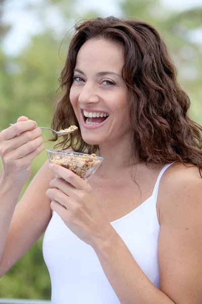 Close-up van mooie vrouw eten granen — Stockfoto