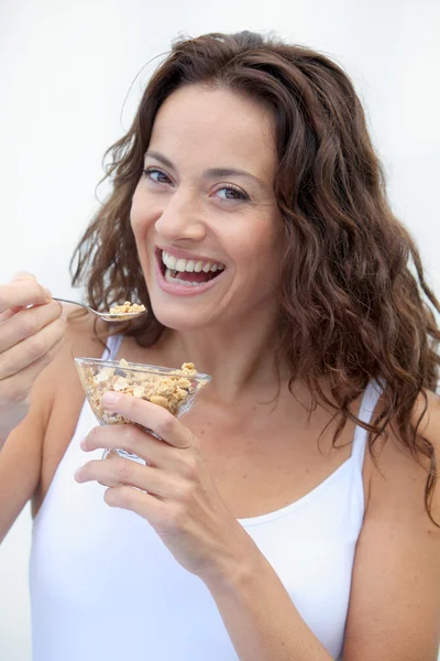 Close-up van mooie vrouw eten granen — Stockfoto