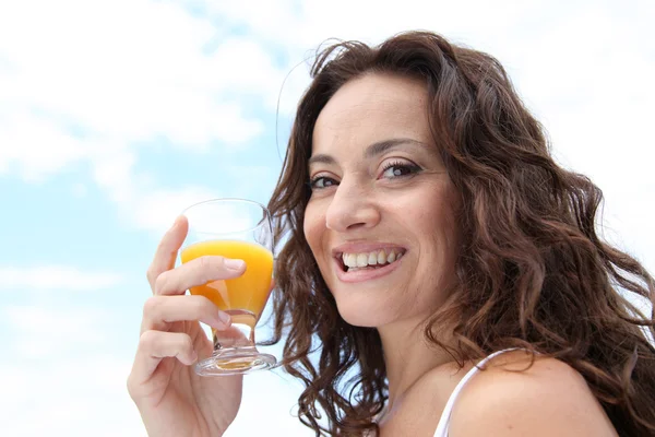 Крупный план красивой женщины, пьющей апельсиновый сок — стоковое фото