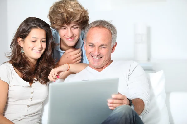 Familia en casa con ordenador portátil —  Fotos de Stock