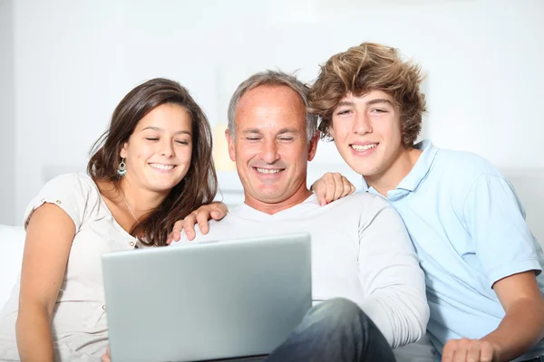 :Familia en casa con ordenador portátil —  Fotos de Stock