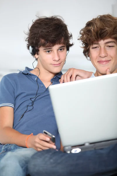 Adolescentes com leitor de música e computador em casa — Fotografia de Stock