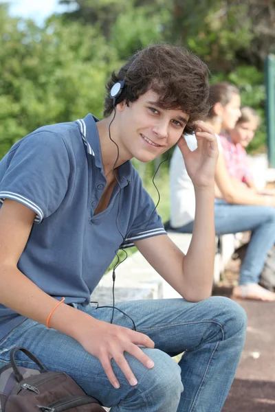 Nastoletni chłopiec z słuchawkami na uszach — Zdjęcie stockowe