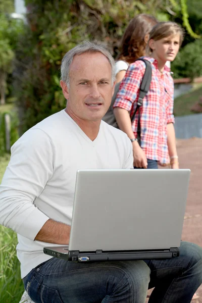 Läraren sitter utanför med bärbar dator — Stockfoto