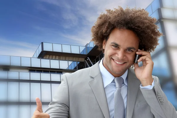 Uomo d'affari al telefono di fronte a un edificio moderno — Foto Stock