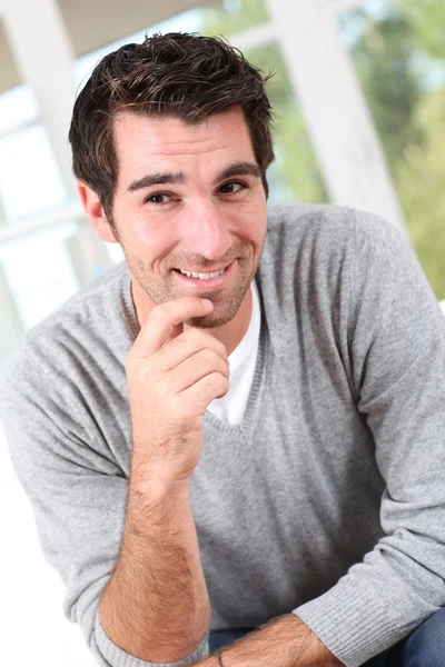 Smiling man with hand on chin Stock Picture