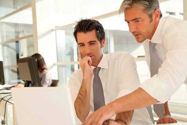 Businessmen working together on laptop computer — Stock Photo, Image