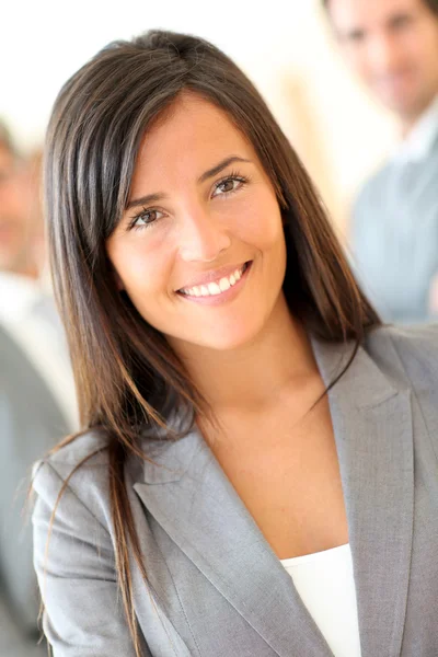 Portrait of beautiful businesswoman standing in front of group Stock Image