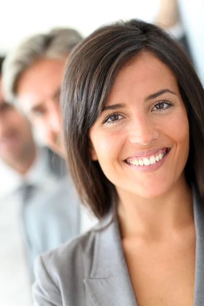 Beautiful saleswoman standing with group of business Stock Image