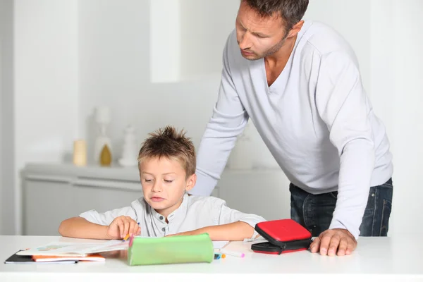 Pai ajudando filho a fazer lição de casa Fotos De Bancos De Imagens