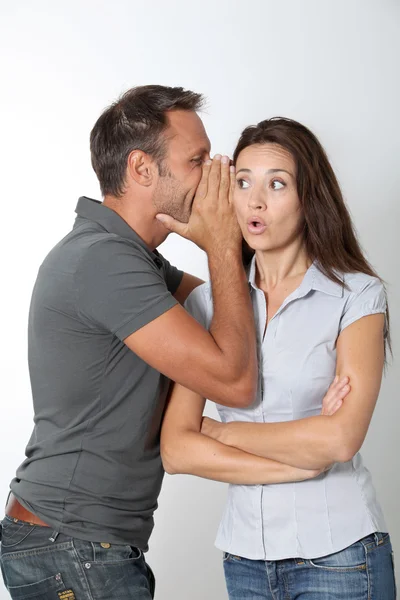 Homme chuchotant à son oreille de petite amie Photo De Stock