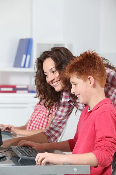 Teacher and children learning to use computer Stock Picture