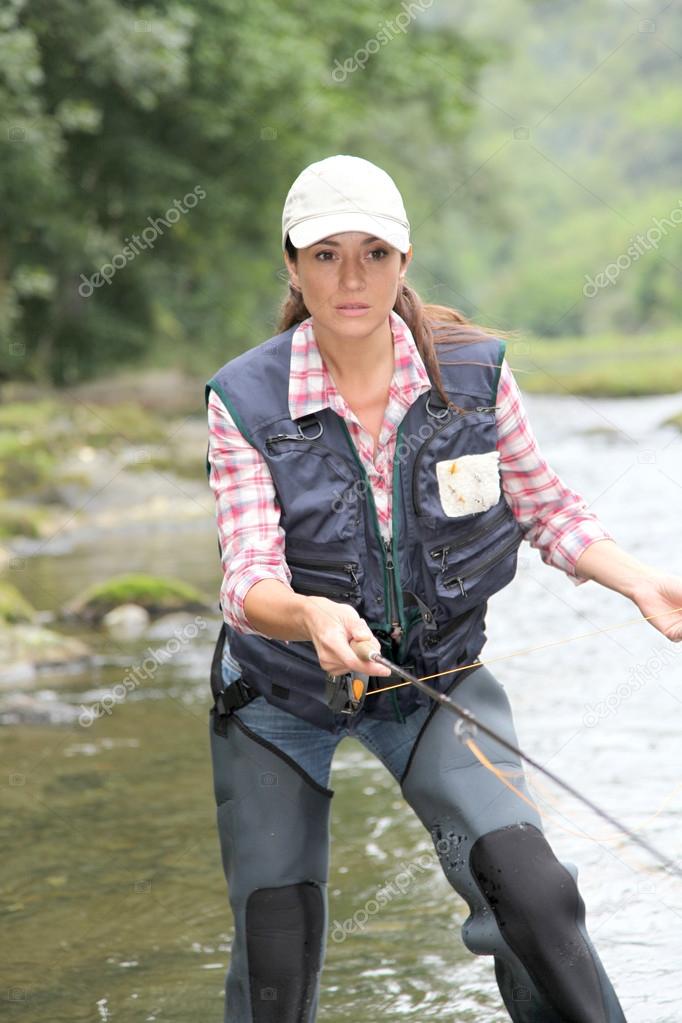 Woman with fly fishing line in river