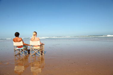 Çift bathchairs önünde denizin içinde dinlendirici
