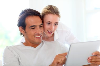 evde genç bir çift elektronik kullanarak tablet