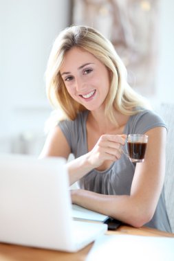 evde dizüstü bilgisayar üzerinde çalışan kadın