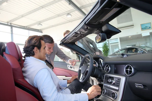 Car seller with couple in car dealership — Stock Photo, Image