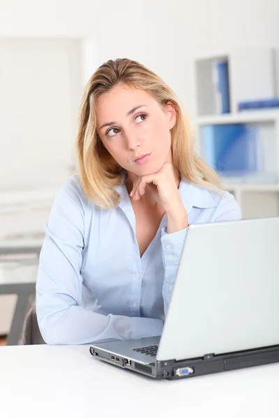 Blond kvinna vid arbete med eftertänksam blick — Stockfoto