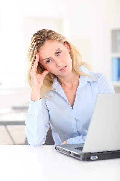 Mujer rubia en el trabajo con dolor de cabeza — Foto de Stock