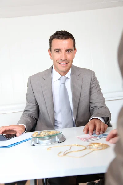 Businessman paying for golden jewels — Stock Photo, Image