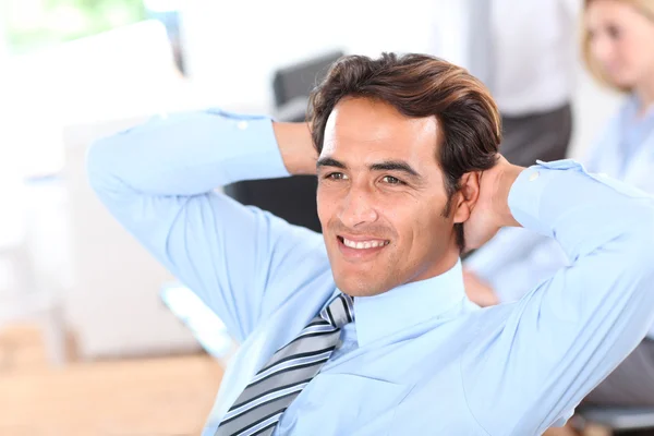 Smiling relaxed businessman in office — Stock Photo, Image