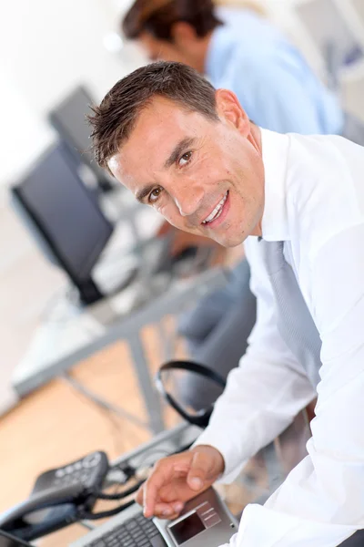 Portret van een lachende zakenman in het kantoor — Stockfoto