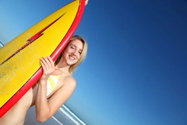 Vacker blond kvinna står med surfbräda — Stockfoto