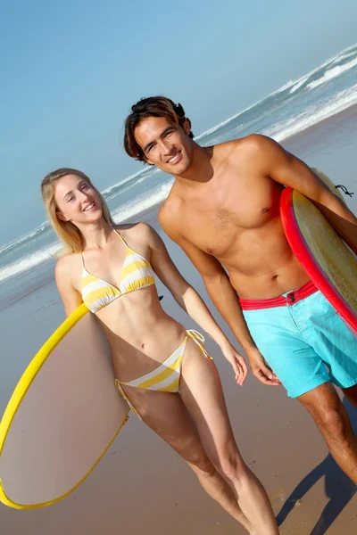 Coppia in spiaggia con tavola da surf — Foto Stock