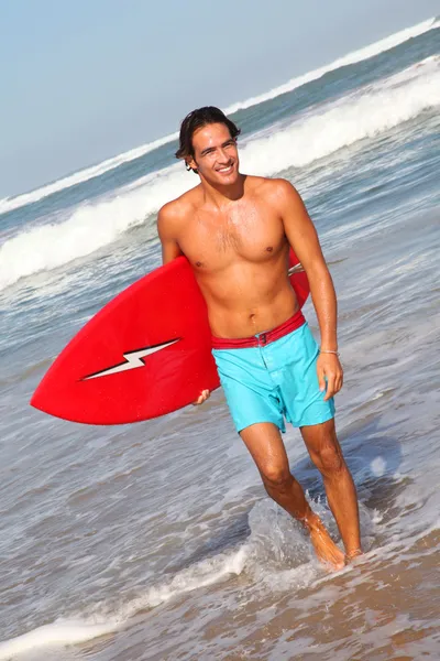 Surfista saliendo del agua con tabla de surf — Foto de Stock