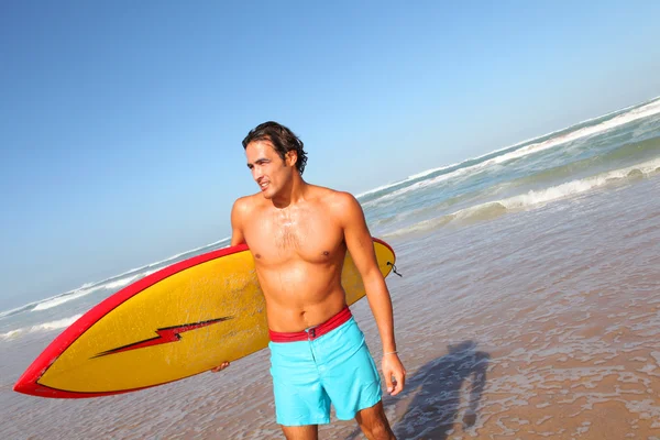 Surfista saliendo del agua con tabla de surf —  Fotos de Stock