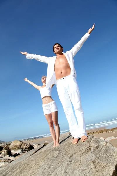 Paar macht Yoga-Übungen am Strand — Stockfoto