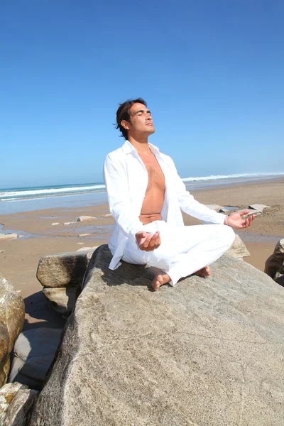 Homem fazendo exercícios de meditação na praia — Fotografia de Stock