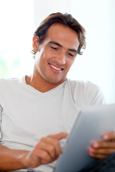 Χαμογελαστός άνθρωπος χρησιμοποιώντας το touchpad στο σπίτι — Φωτογραφία Αρχείου