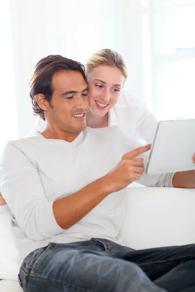 Casal jovem usando tablet eletrônico em casa — Fotografia de Stock