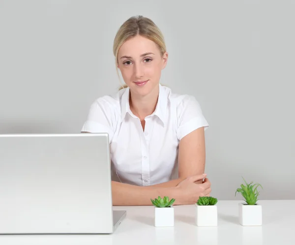 Femme blonde assise par ordinateur et plantes vertes — Photo