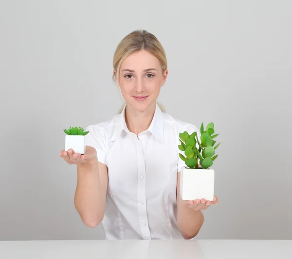 Woman holding green plant — Stock Photo, Image